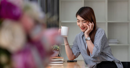 Young woman with coffee cup on table