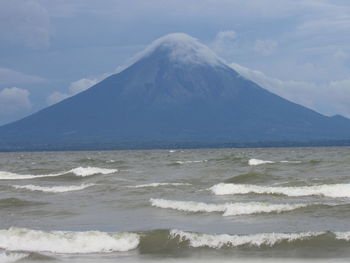 Scenic view of sea and mountains against sky