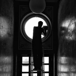 Rear view of silhouette woman standing in corridor