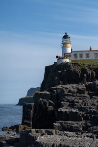 Lighthouse by sea against sky