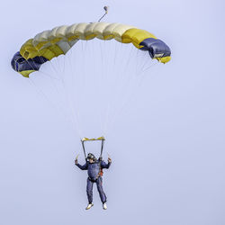 Low angle view of man paragliding against sky