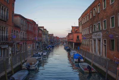 Boats in canal along buildings