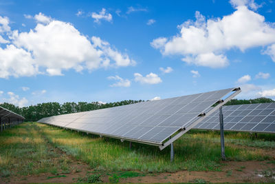 Solar panels on field against sky