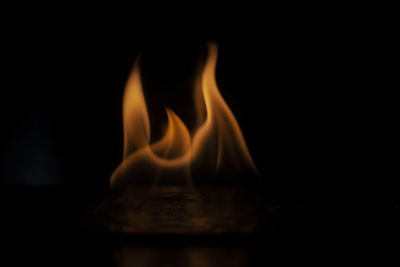 Close-up of lit candle in darkroom