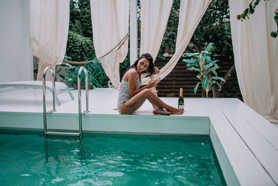 Portrait of woman sitting in swimming pool