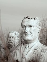 Close-up portrait of a man against bare tree