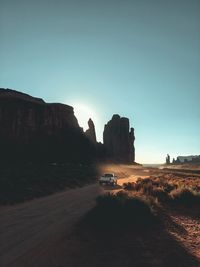 Car on road amidst rocks against clear sky