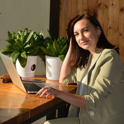 Portrait of businesswoman using laptop on table in office