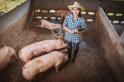 High angle portrait of female veterinarian smiling while standing in shed