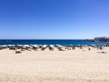 Scenic view of beach against clear blue sky