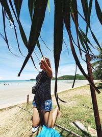 Woman standing on beach against sky