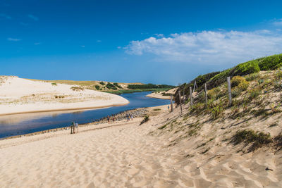 Scenic view of beach against blue sky