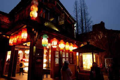 People in illuminated building at night