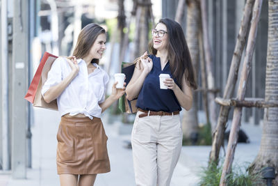 Woman standing with arms raised in city