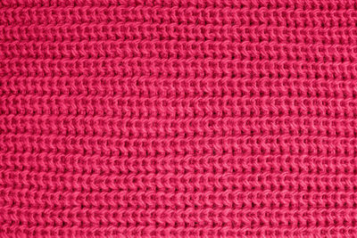 Woolen knitted texture of vivid magenta color close-up