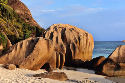 Rock formation by sea against sky