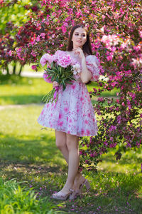 Portrait of young woman standing on field