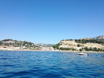 Boats in sea against clear sky