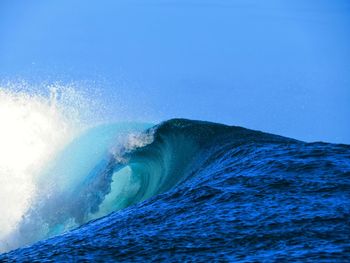 Scenic view of sea waves against clear blue sky