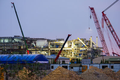 Cranes at construction site against sky