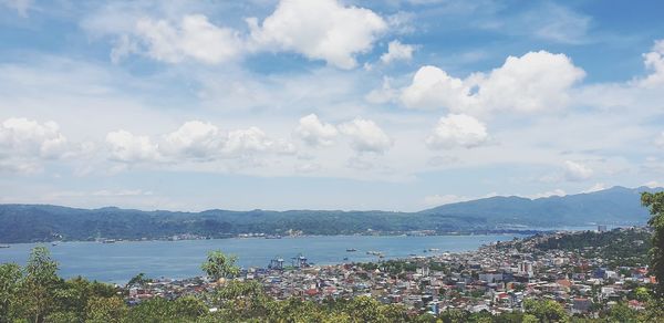 High angle view of townscape by sea against sky