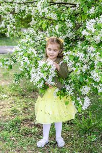Portrait of young woman standing by plants