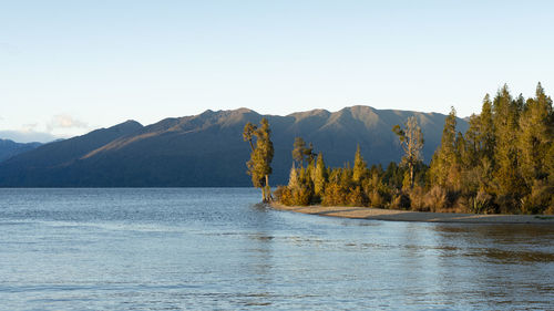 Scenic view of lake and mountains against clear sky