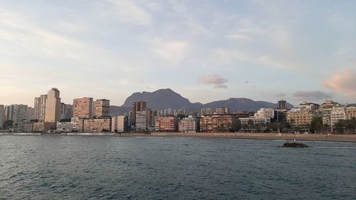 View of buildings in city against cloudy sky