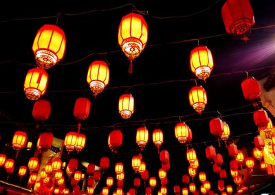 Low angle view of illuminated lanterns hanging at night