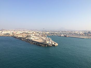 Scenic view of sea by buildings against clear sky