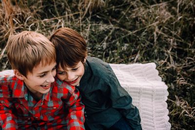 Cheerful siblings sitting in park