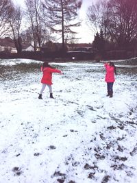 Girl playing on snow covered landscape