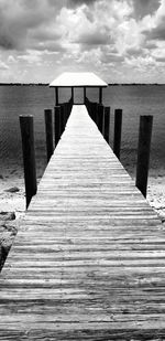 Wooden pier on sea against sky