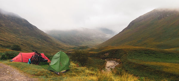 Scenic view of mountains against sky with tents