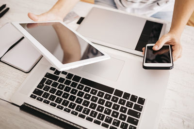 Young woman using different devices to work on the network