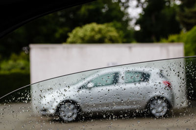 Car parked on street seen through wet window