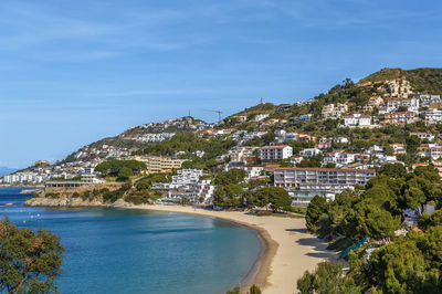 Townscape by sea against blue sky