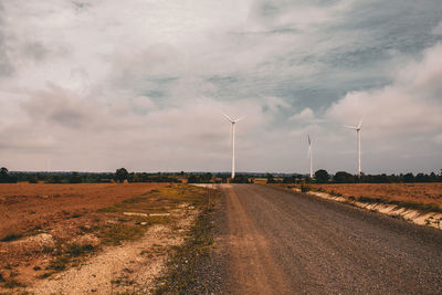 Road amidst field against sky