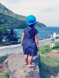 Girl looking at sea against sky