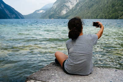 Rear view of woman photographing sea