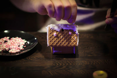 Cropped hand of person preparing food on table