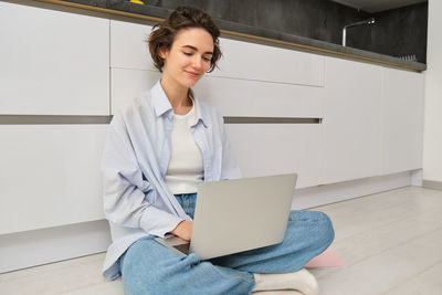Portrait of young businesswoman using laptop while sitting at home