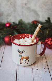 Close up of hot chocolate on wooden background with christmas decor.