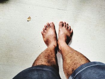 Low section of man standing on tiled floor