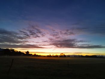 Scenic view of silhouette field against sky during sunset