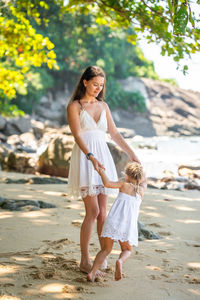 Side view of mother and daughter walking on street