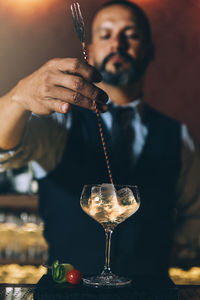 Mature bartender preparing cocktail on bar counter