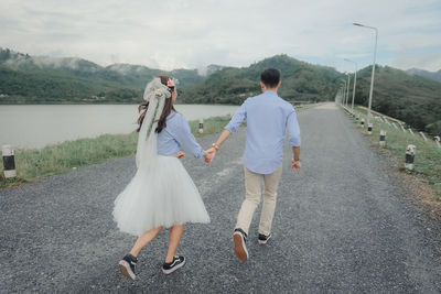 Rear view of couple walking on road