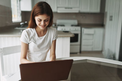 Young woman using laptop at home