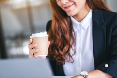 Midsection of woman drinking coffee